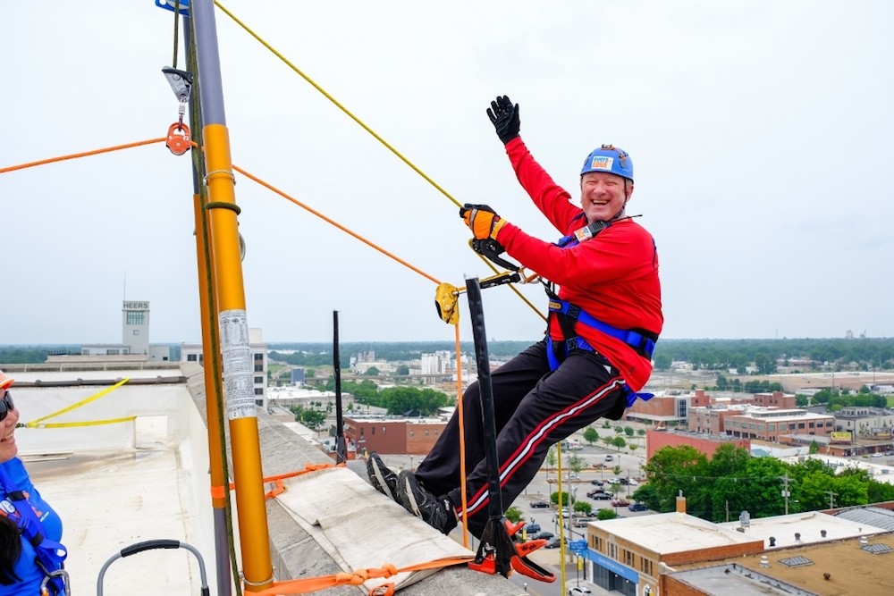 Jack Henry Banking President Stacey Zengel prepares to rappel down Sky Eleven to raise money for Child Advocacy Center. He personally raised $6,730.